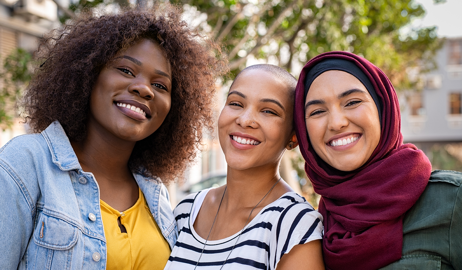 Three women of color smiling together