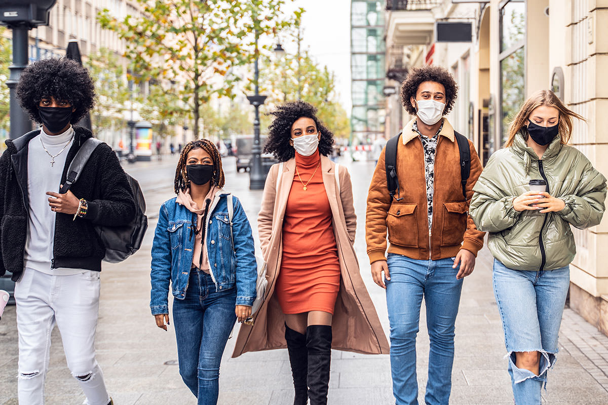 Diverse group of people walking with masks on.