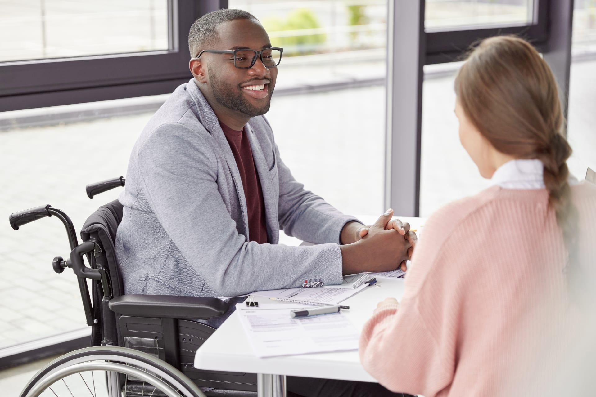 Man in wheelchair shaking hands at meeting