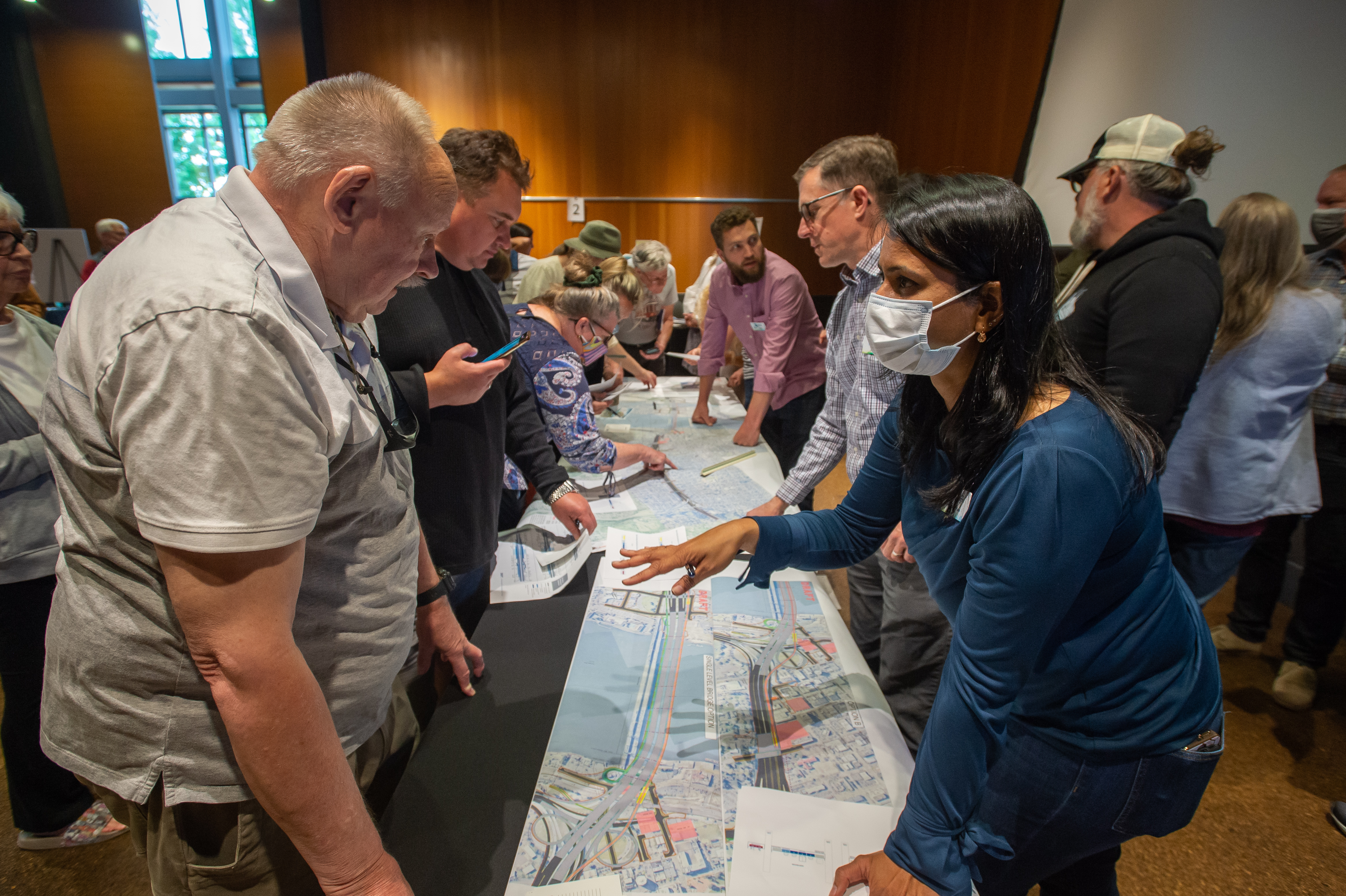 Image of IBR staff and community members discussing the program over a map.